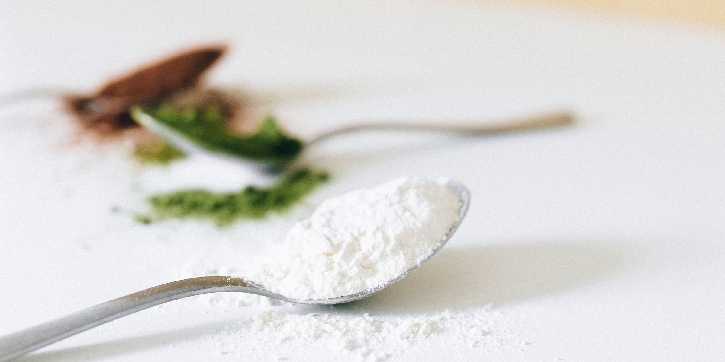 Spoon of white powder on a white surface